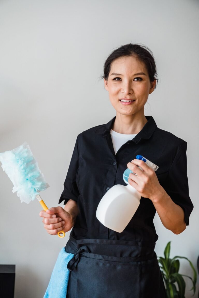 Facility staff member with cleaning spray and duster