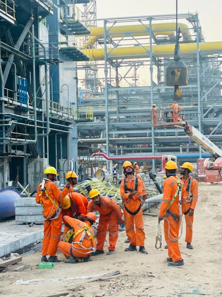 Construction workers in safety gear at an industrial site