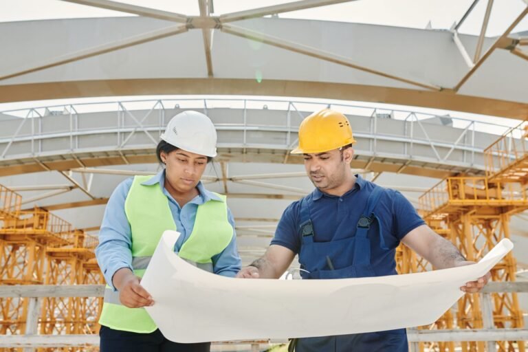 Site engineers reviewing building plans at a construction site